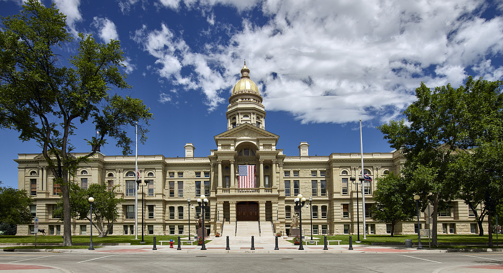 The Wyoming State Capitol building with its gold dome under a blue sky